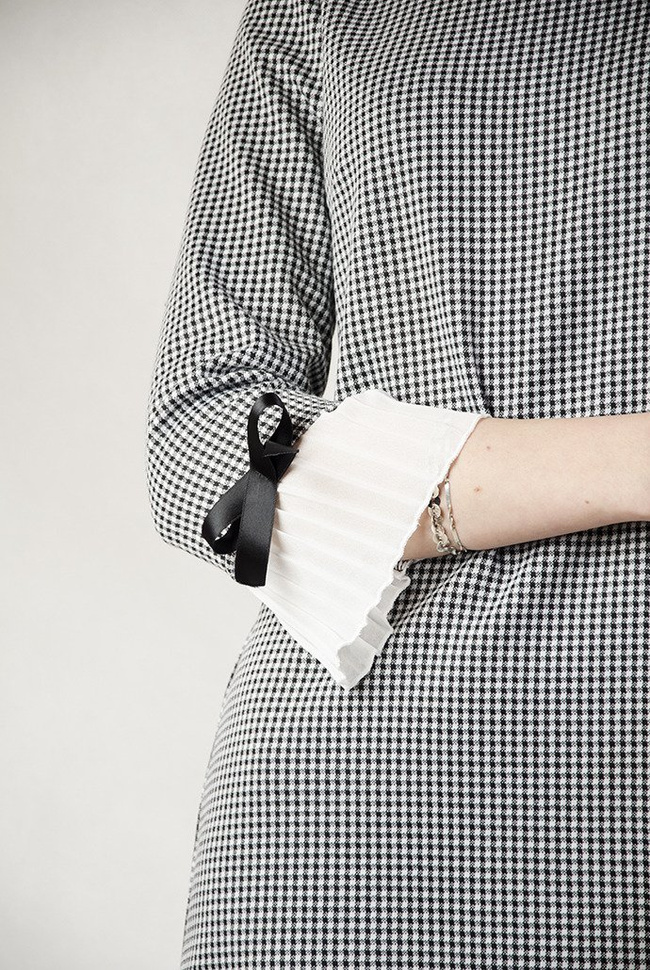 Asymetryczna sukienka w pepitkę z plisowaniem przy rękawie.