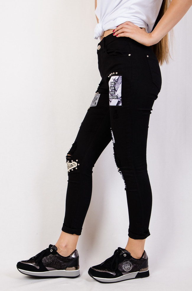 Czarne spodnie jeansowe z naszywkami i dziurami