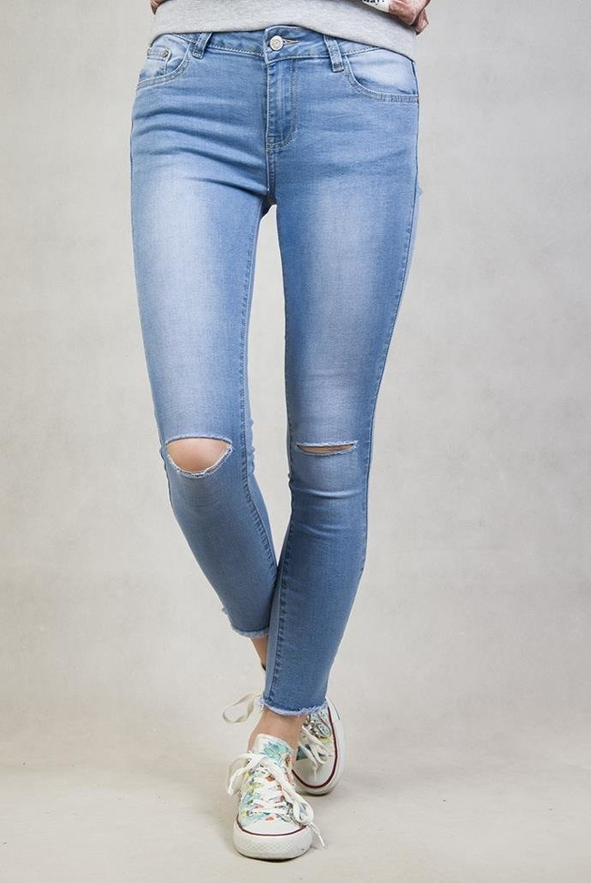 Spodnie jeansowe z dziurami na kolanach oraz frędzlami przy nogawkach