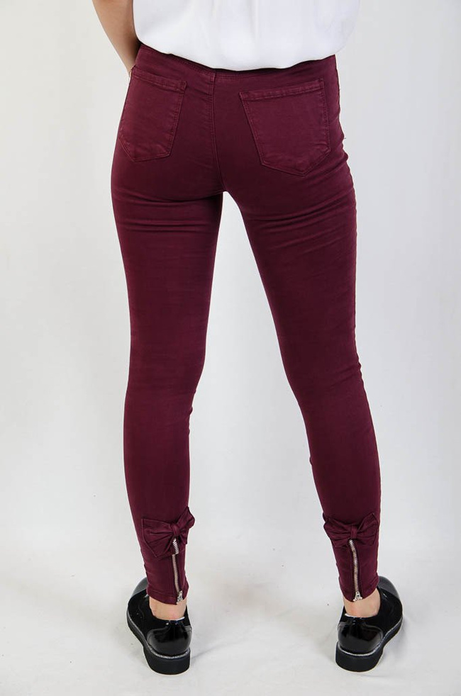 Bordowe spodnie jeansowe z zamkiem na nogawce oraz kokardą