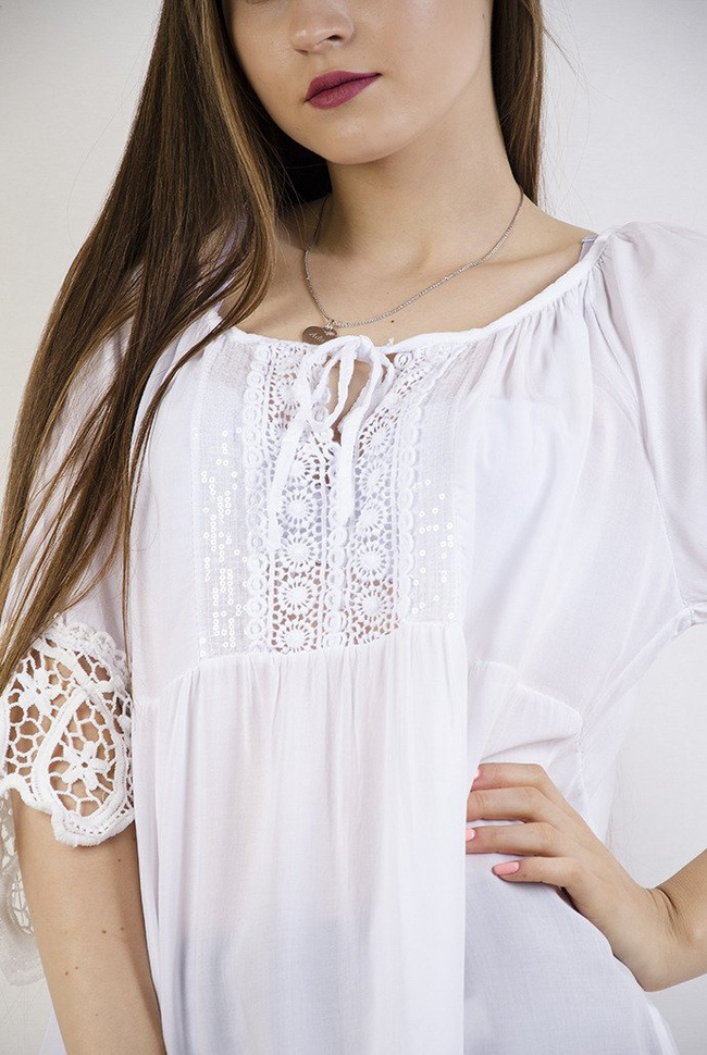 Biała bluzka z ażurowymi wstawkami oraz wiązaniem przy dekolcie