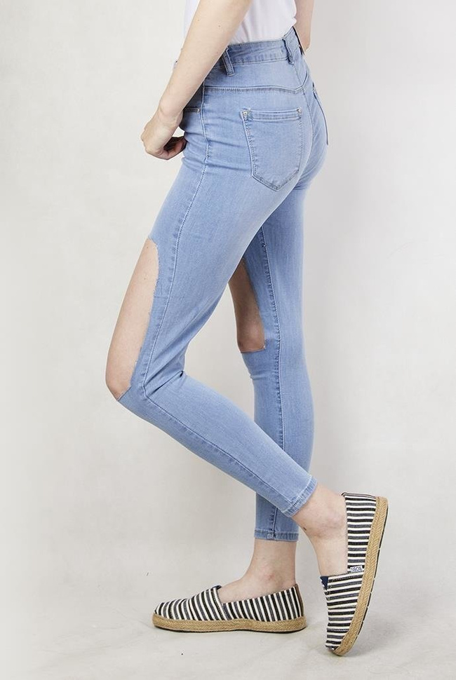 Jasne spodnie jeansowe z dużymi dziurami