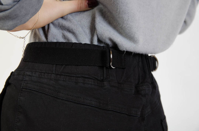 Czarne spodnie jeansowe z gumą w pasie oraz marszczeniem na kolanach