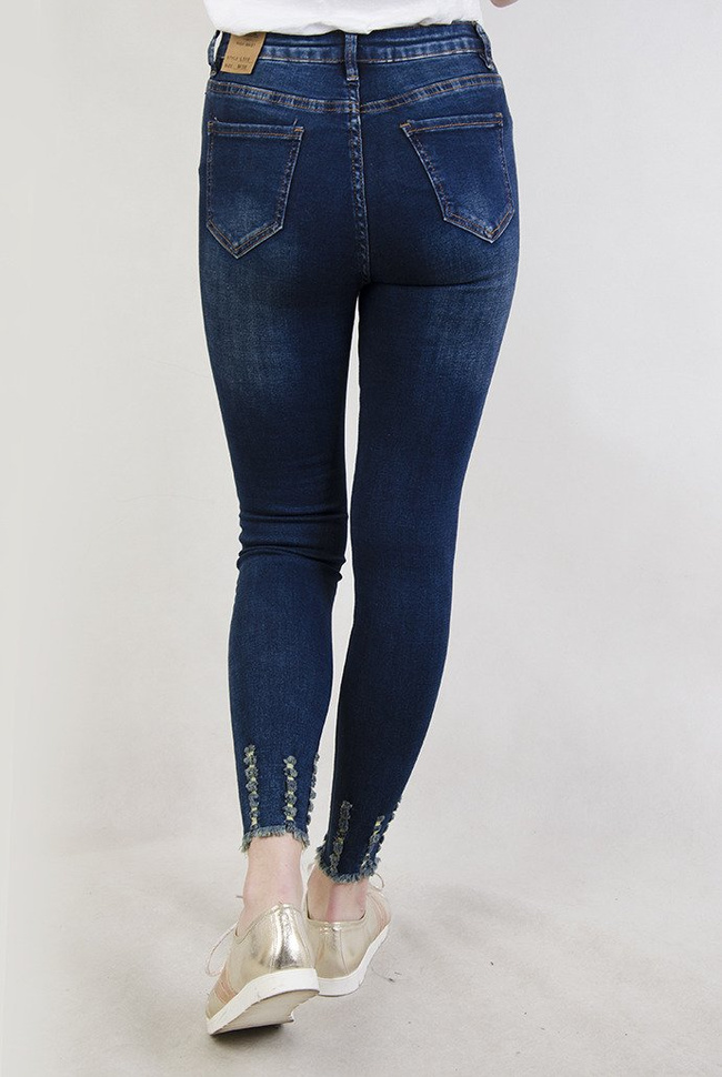  Ciemne spodnie jeansowe z wysokim stanem oraz szarpaniami przy nogawce