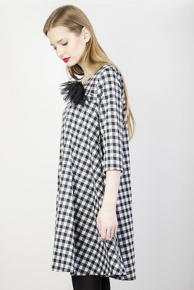 Rozkloszowana biało-czarna sukienka w kratę z broszką