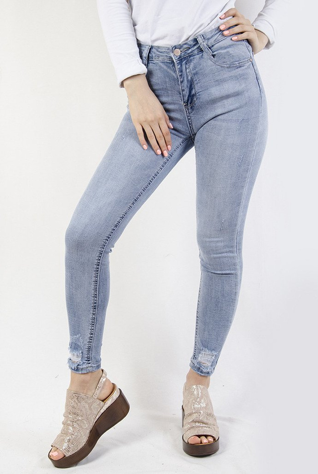 Jasne spodnie jeansowe z przetarciami na dole nogawki