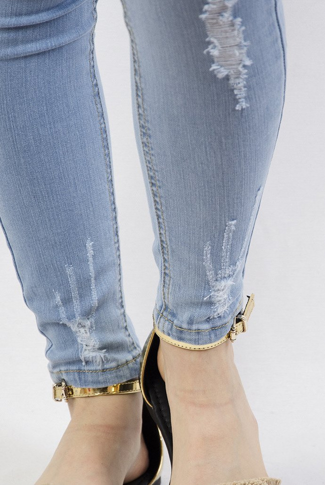 Jasne spodnie jeansowe z dużymi przetarciami