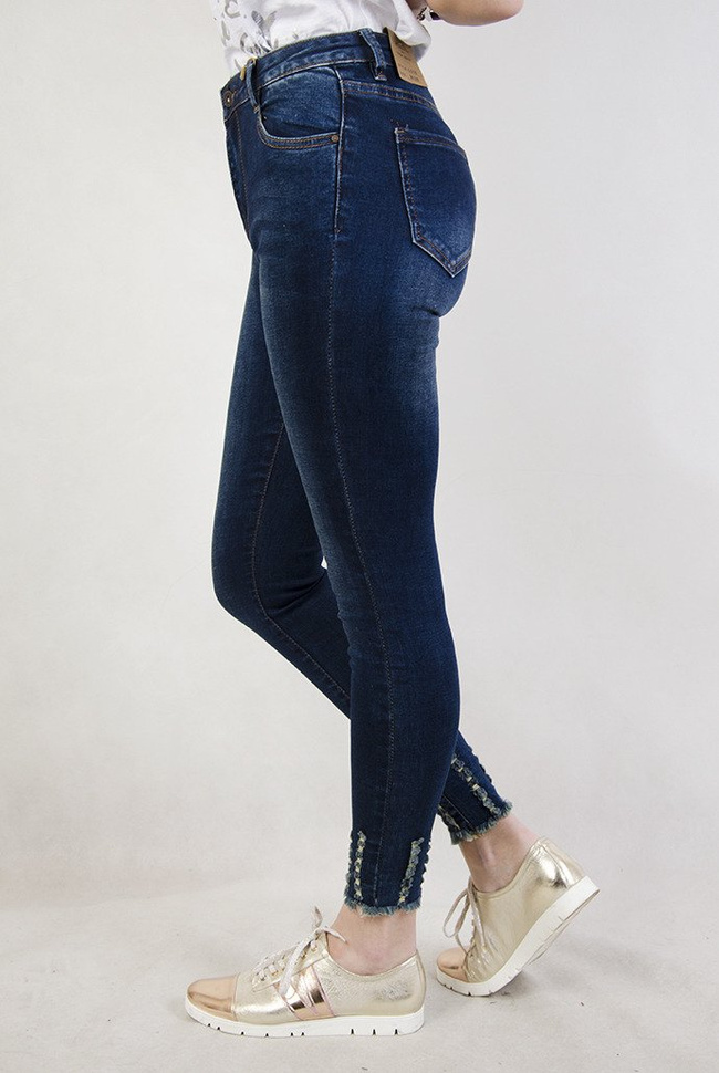 Ciemne spodnie jeansowe z wysokim stanem oraz szarpaniami przy nogawce