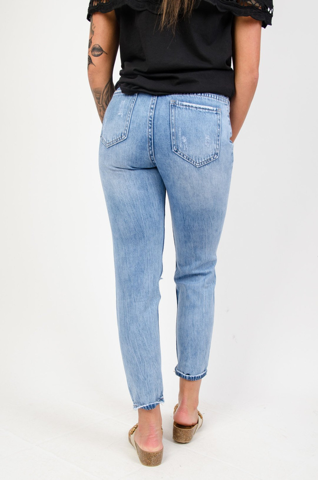 Jeansowe boyfriendy z dziurami i drobnym napisem pod kieszenią