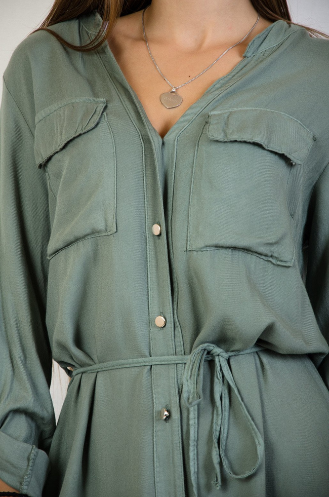 Zielona sukienka zapinana na złote guziki wiązana w pasie
