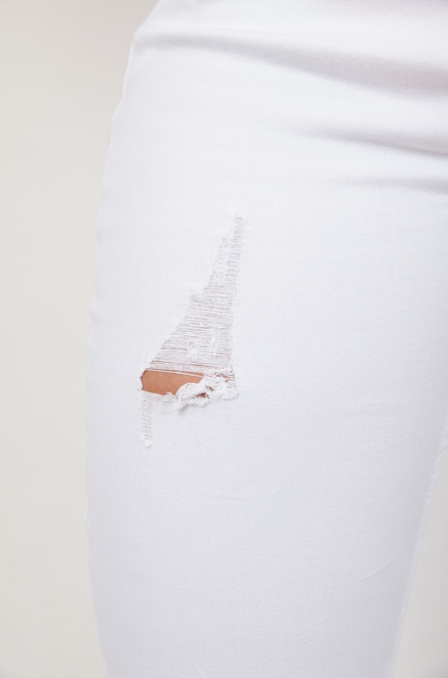 Białe spodnie jeansowe z przetarciami zapinane na guziki