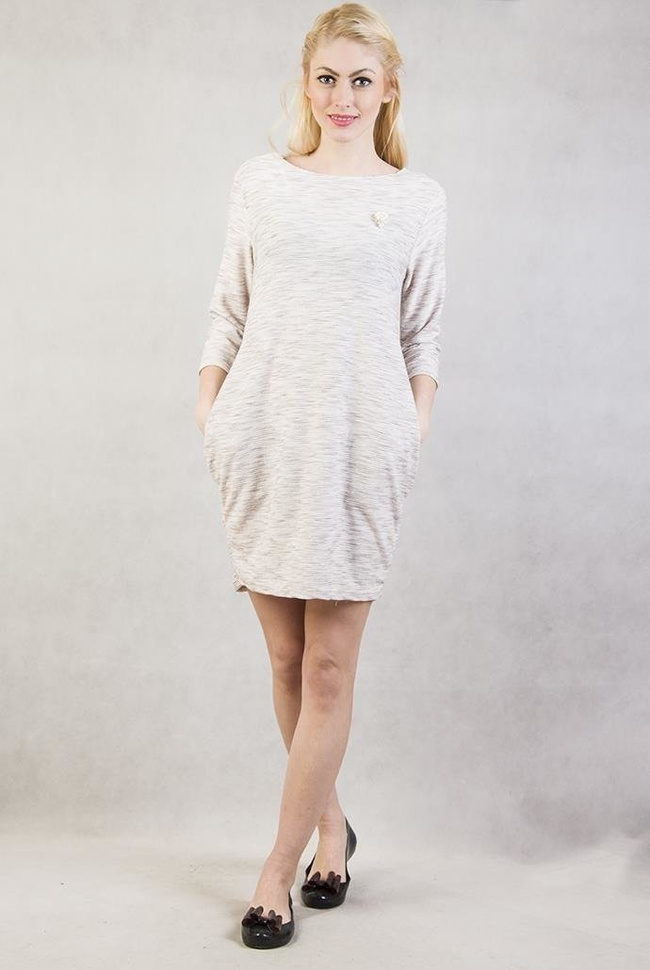 Beżowa tunika z dwoma kieszeniami oraz broszką