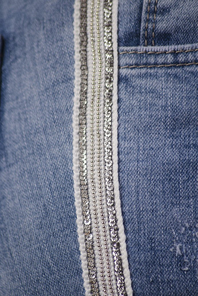 Jasne spodnie jeansowe z lampasami z cekinów oraz perełek