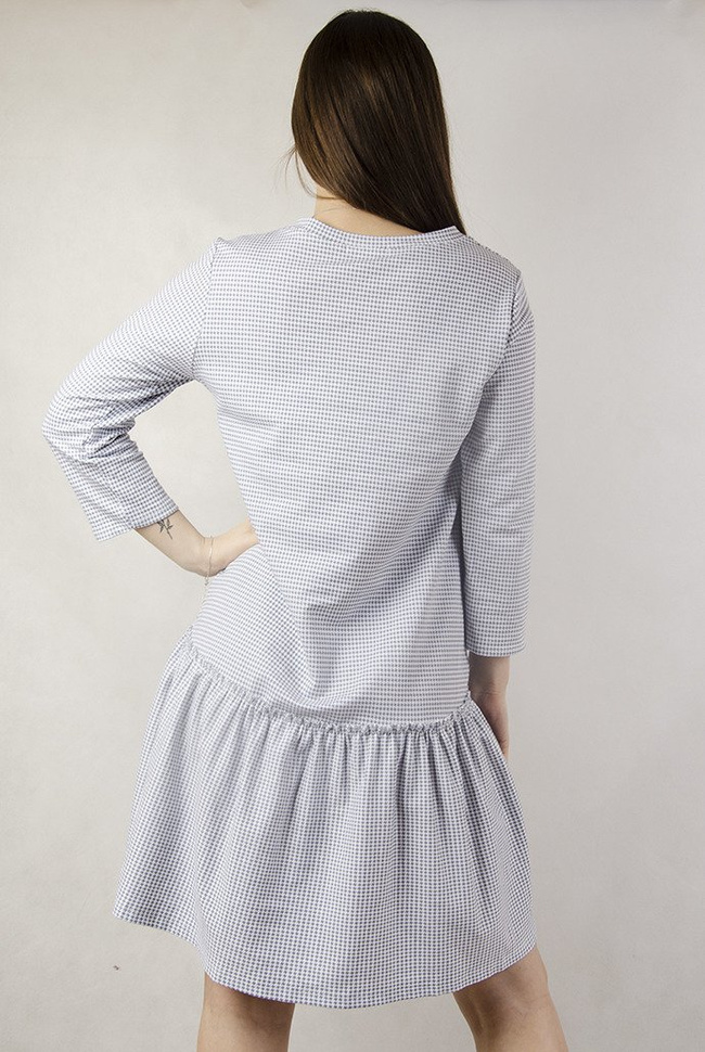 Biała sukienka w szare wzory  z naszywką i falbaną na dole