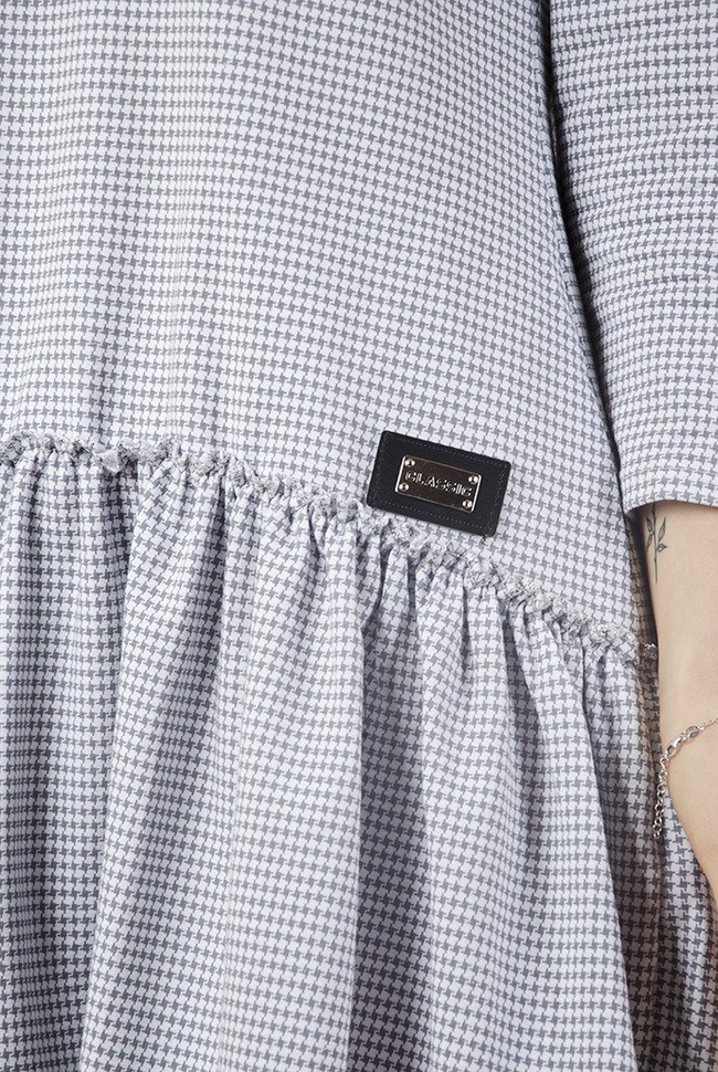 Biała sukienka w szare wzory z naszywką i falbaną na dole