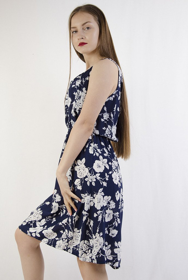 Granatowa sukienka w białe kwiaty z zamkiem z tyłu, zakończonym perłą.