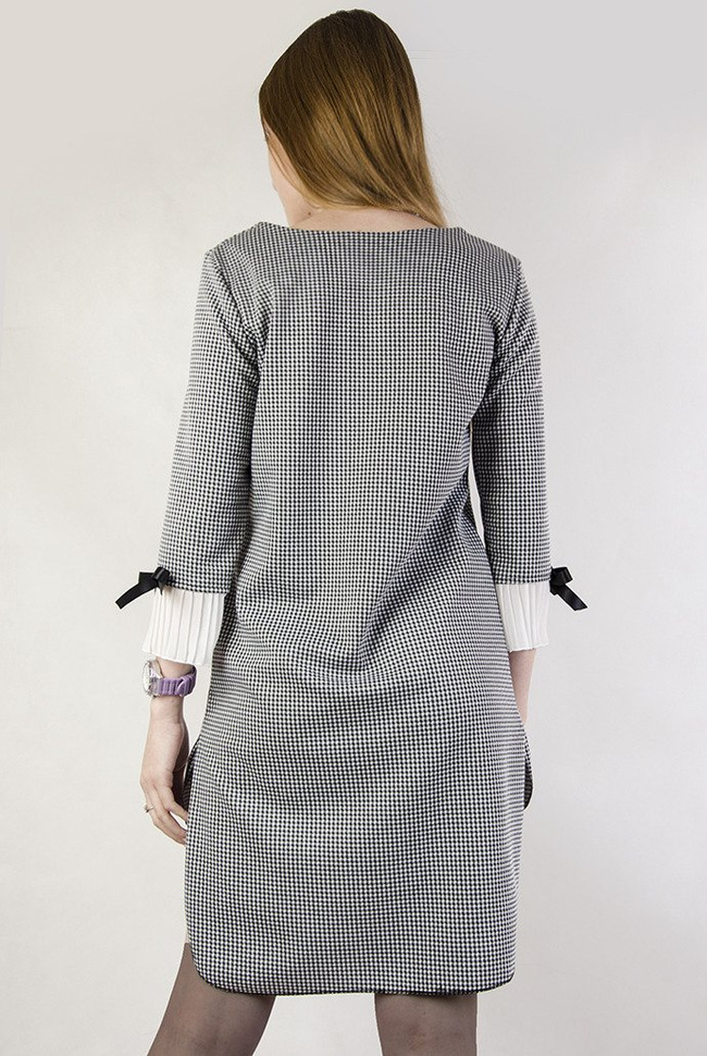 Asymetryczna sukienka w pepitkę z plisowaniem przy rękawie.