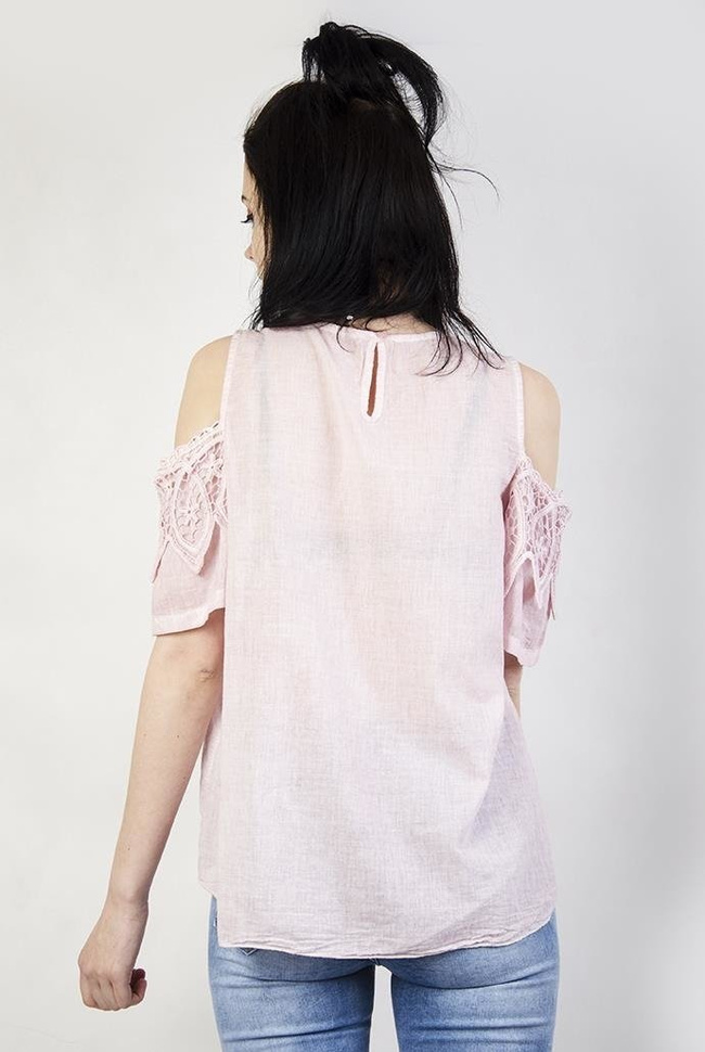 Jasnoróżowa bluzka z wyciętymi ramionami i ażurowym zdobieniem