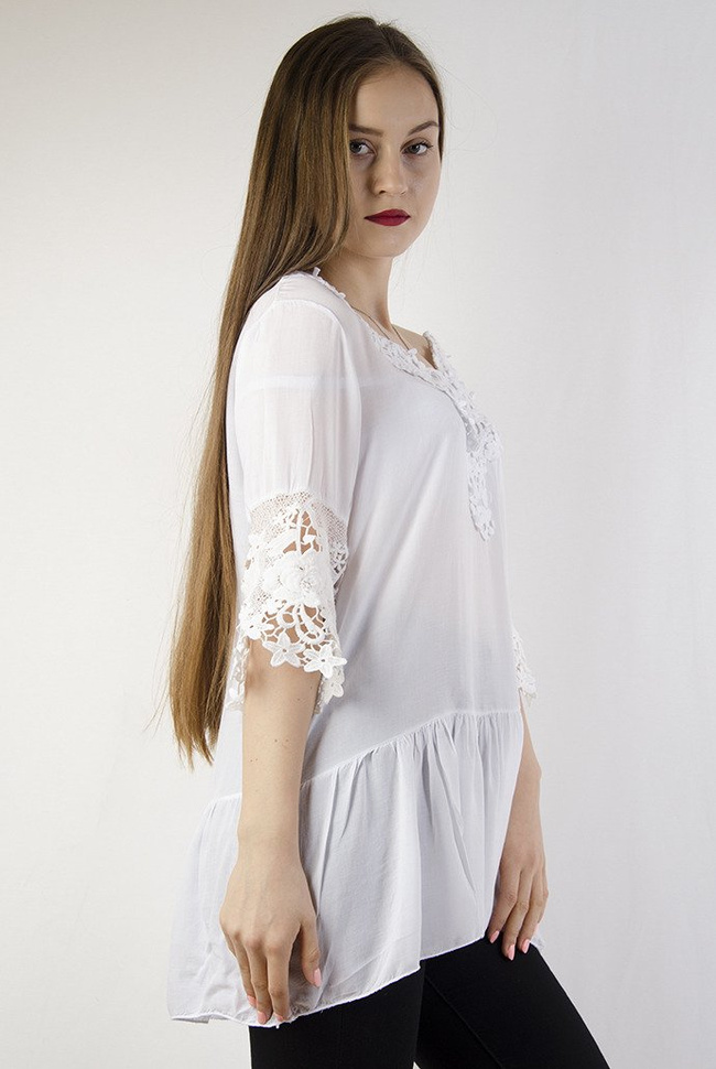 Biała bluzka z ażurowym dekoltem oraz falbanką na dole