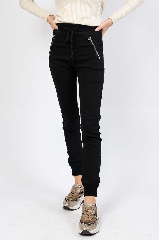 Czarne spodnie ze ściągaczem na dole oraz gumką w pasie