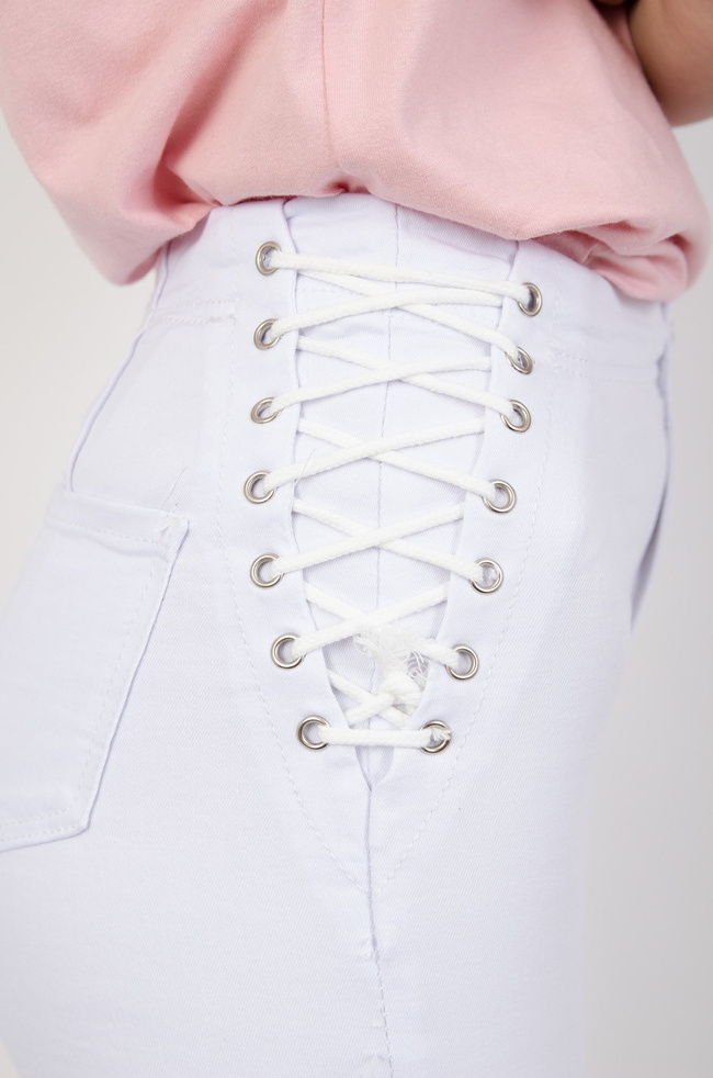 Białe jeansowe spodnie modelujące z wiązaniem na boku