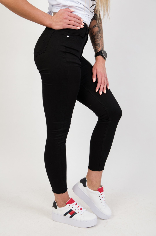 Czarne spodnie jeansowe z przetarciami zapinane na guziki