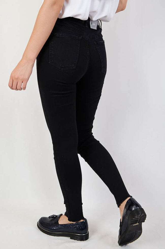 Czarne jeansowe spodnie z przetarciami oraz szarpaniem na dole nogawki