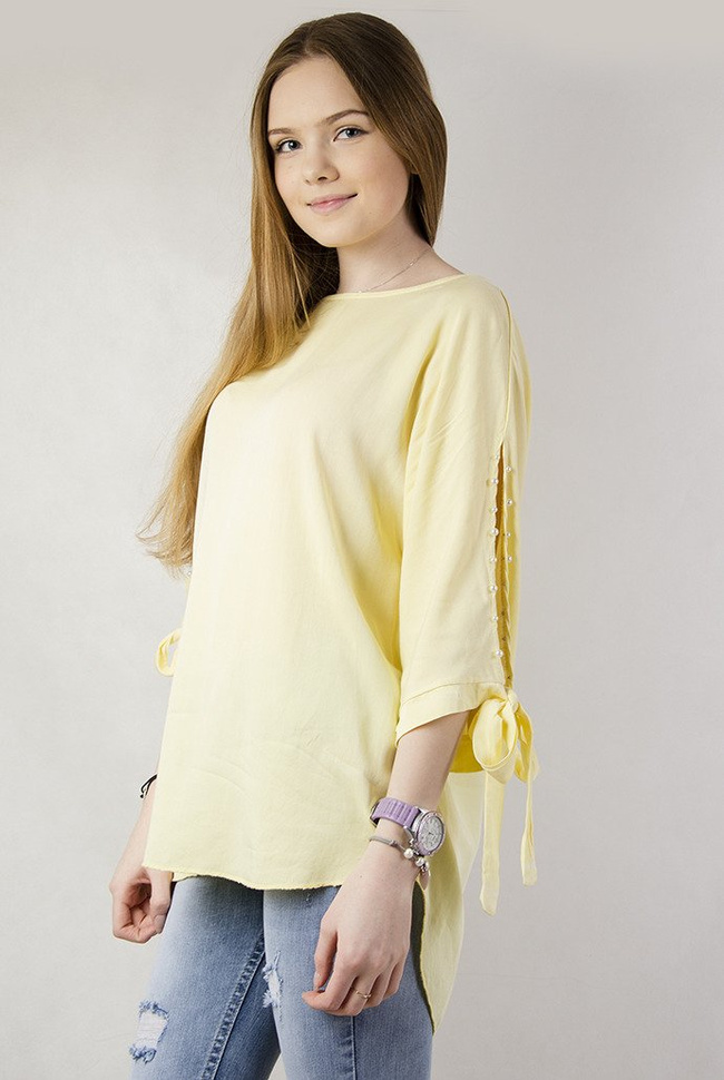Żółta asymetryczna bluzka z wiązaniem przy rękawie oraz perełkami