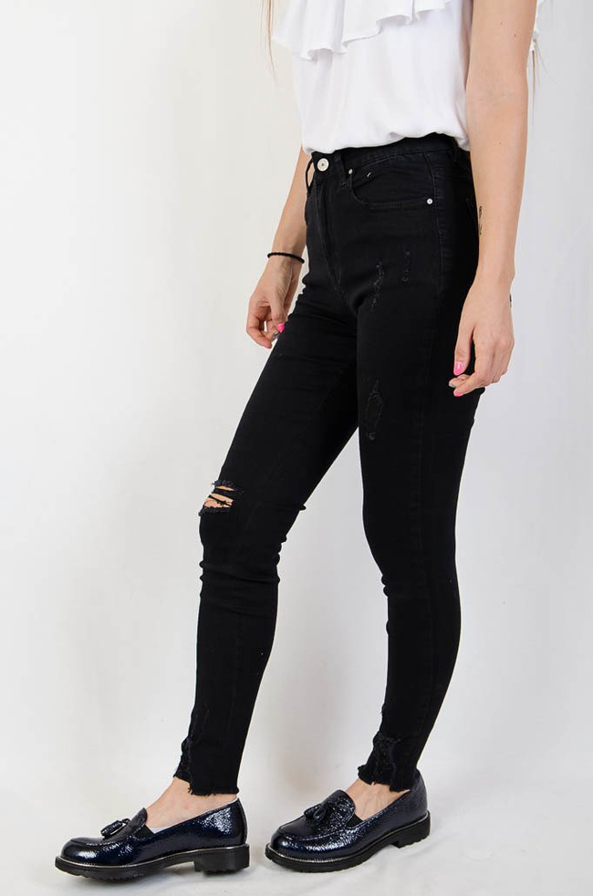 Czarne jeansowe spodnie z przetarciami oraz szarpaniem na dole nogawki
