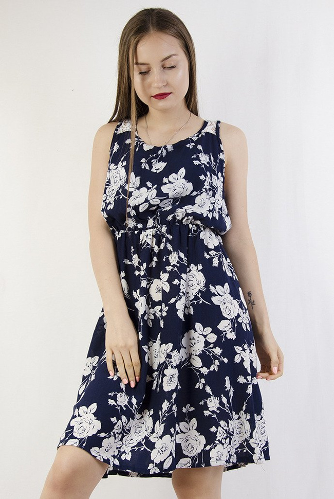Granatowa sukienka w białe kwiaty z zamkiem z tyłu, zakończonym perłą.