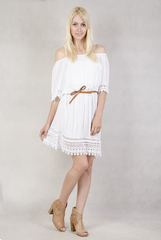 Biała sukienka z koronką przy rękawach.