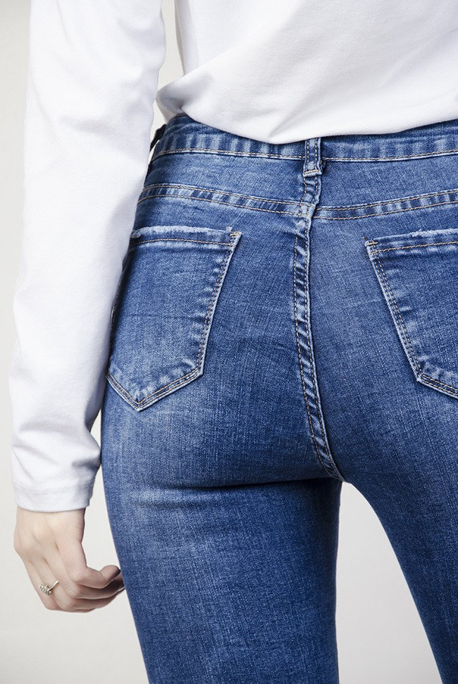 Spodnie jeansowe z przetarciami oraz wywijaną nogawką