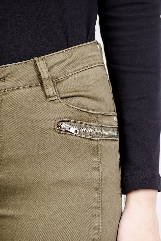 Zielone spodnie rurki jeansowe z zamkami i przeszyciami