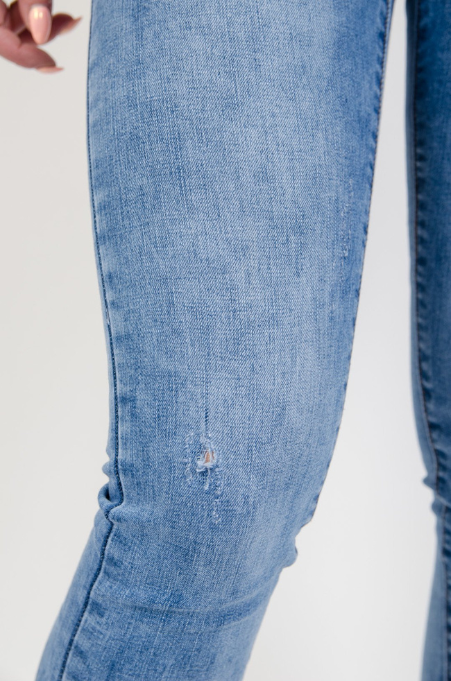 Jasne spodnie jeansowe z delikatnymi przetarciami