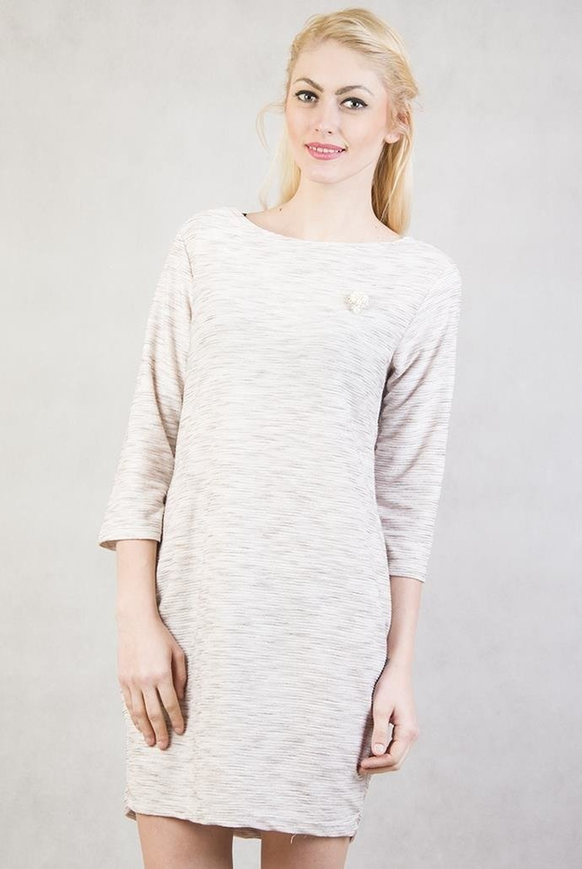 Beżowa tunika z dwoma kieszeniami oraz broszką