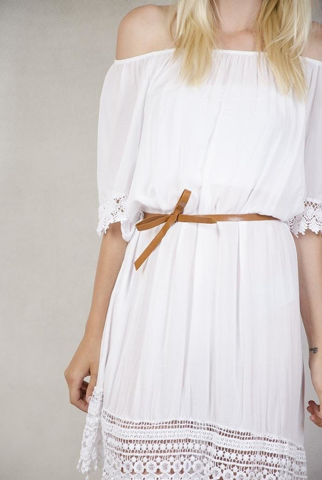 Biała sukienka z koronką przy rękawach.