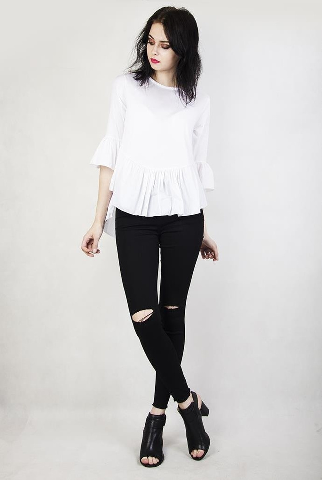 Biała bluzka z falbanami przy rękawach oraz na dole