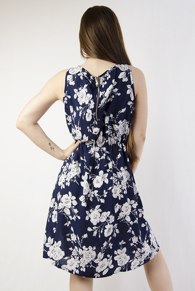 Granatowa sukienka w białe kwiaty z zamkiem z tyłu, zakończonym perłą.