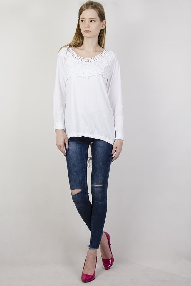 Biała bluzka z ażurowymi zdobieniami przy dekolcie oraz ze ściągaczem na dole