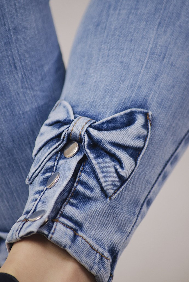 Jasne spodnie jeansowe z kokardami przy nogawce