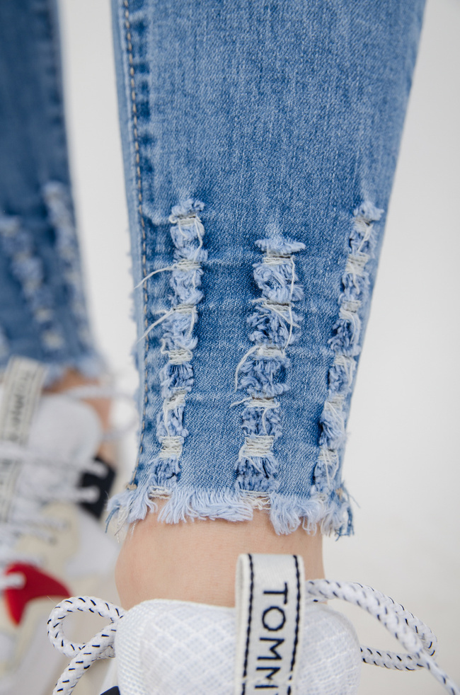 Jasne spodnie jeansowe z dziurami