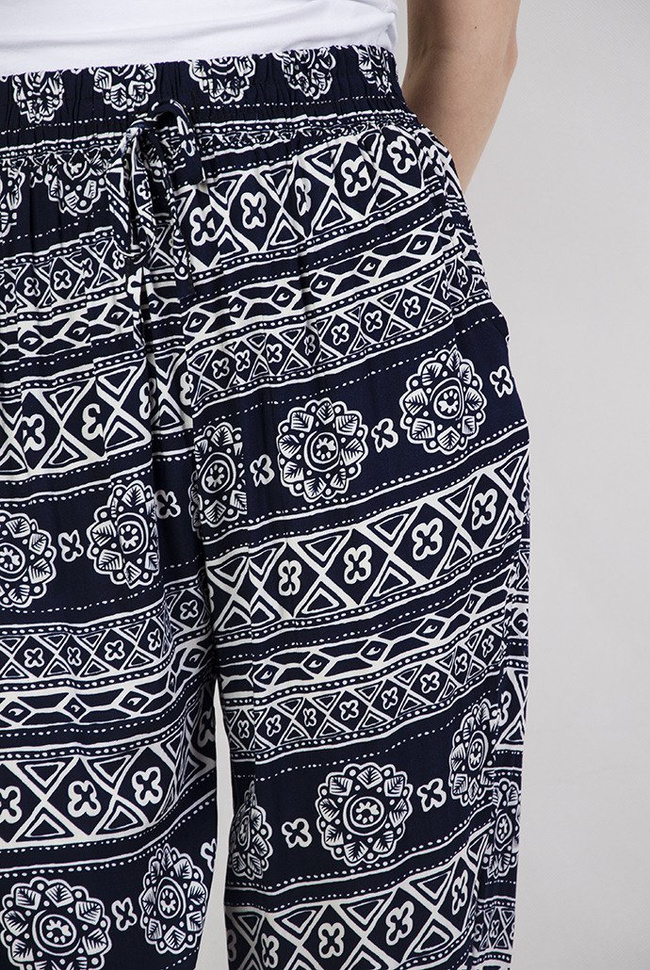 Granatowe spodnie alladynki w kwiaty i trójkąty