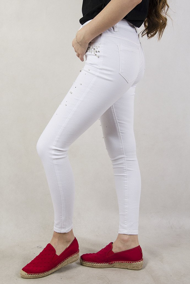 Białe spodnie z przetarciami oraz koralikami