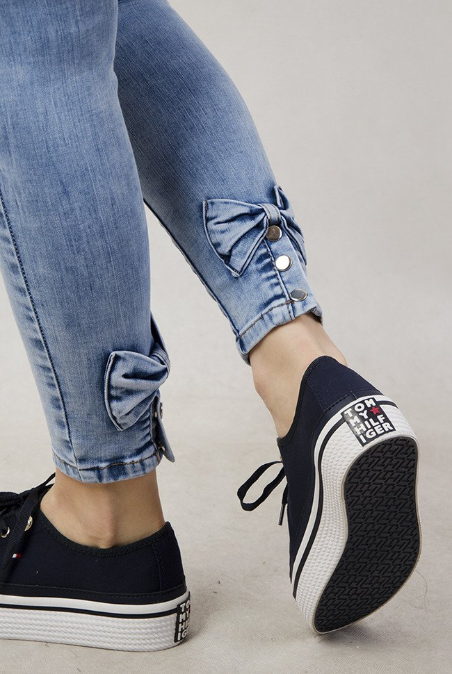 Jasne spodnie jeansowe z kokardami przy nogawce