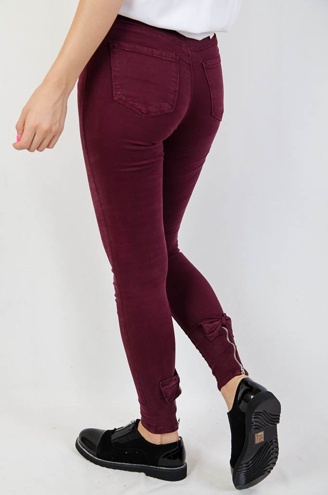 Bordowe spodnie jeansowe z zamkiem na nogawce oraz kokardą