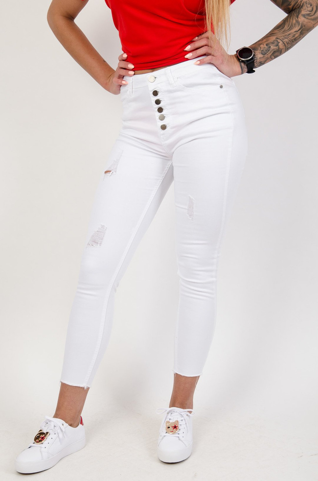 Białe spodnie jeansowe z przetarciami zapinane na guziki