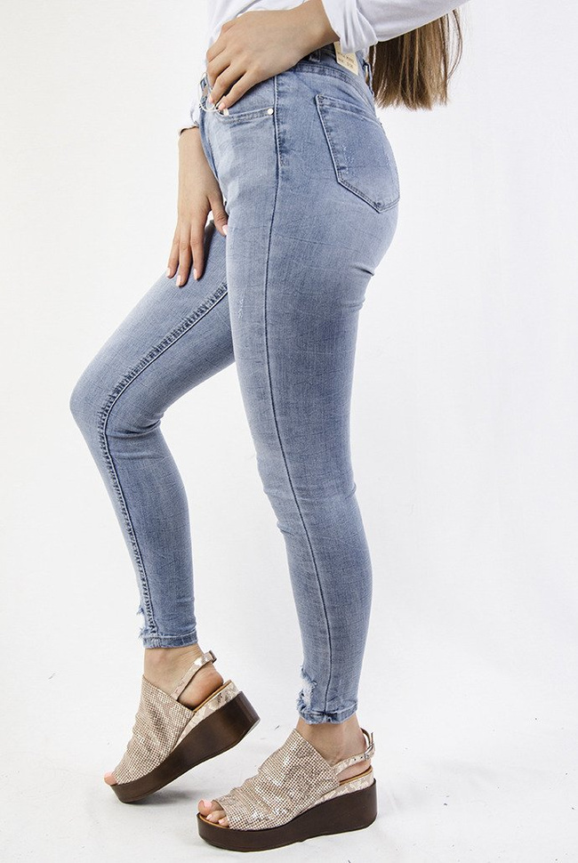 Jasne spodnie jeansowe z przetarciami na dole nogawki