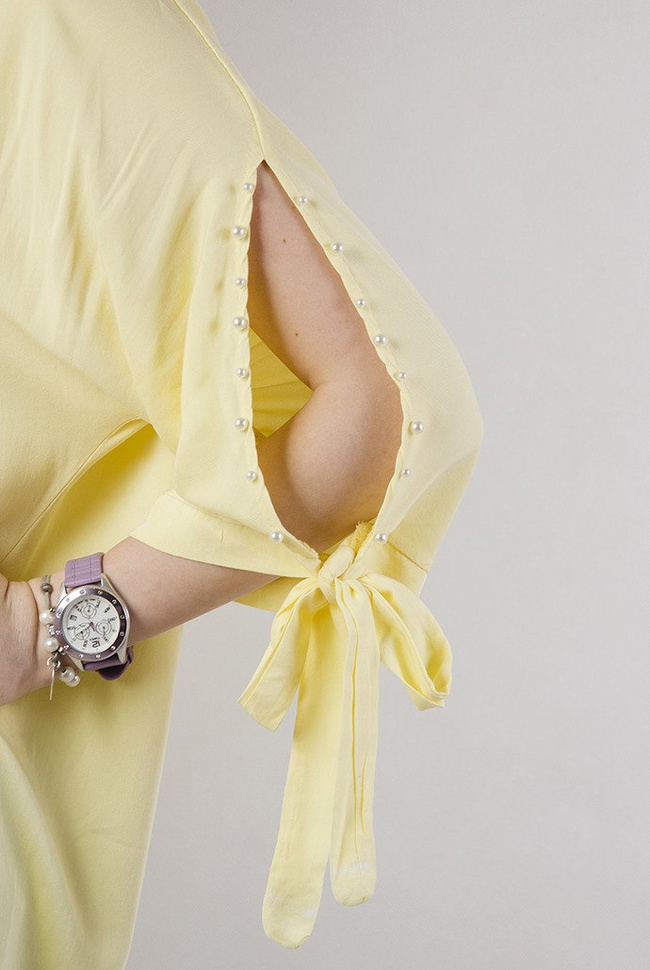 Żółta asymetryczna bluzka z wiązaniem przy rękawie oraz perełkami