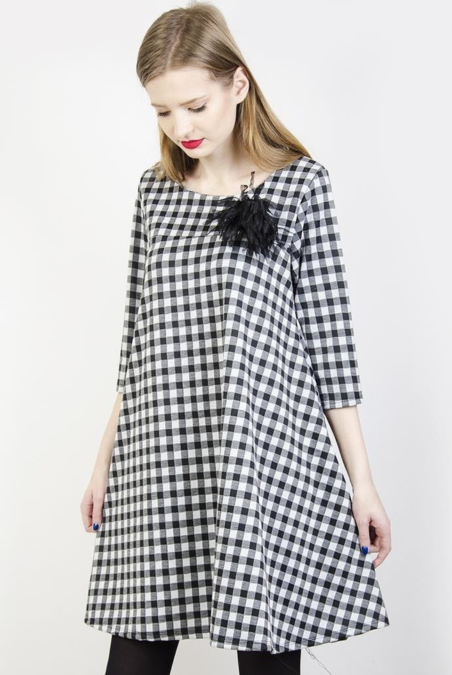 Rozkloszowana biało-czarna sukienka w kratę z broszką