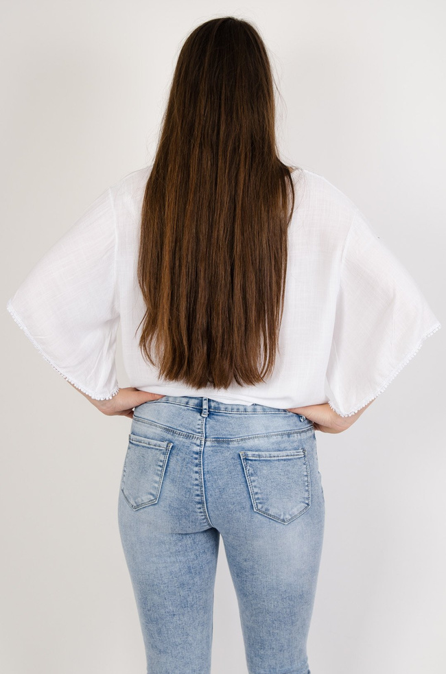 Biała bluzka z szerokimi rękawami wiązana na przodzie